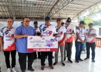 AB. Rauf Yusoh menyampaikan replika cek RM25,000 kepada SMK Seri Pengkalan pada majlis penutup Jelajah Ketua Menteri Sayang Rakyat DUN Machap Jaya di Dewan Terbuka Felda Tun Ghafar, Menggong, Alor Gajah, hari ini. - UTUSAN/AMRAN MULUP