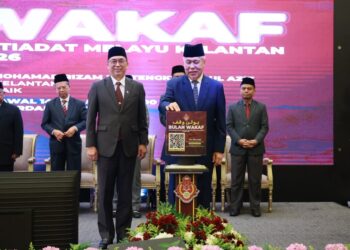 TENGKU Muhammad Rizam Tengku Abdul Aziz (kiri) semasa melakukan gimik pelancaran bulan wakaf MAIK di Kota Bharu, Kelantan semalam-UTUSAN/KAMARUL BISMI KAMARUZAMAN.