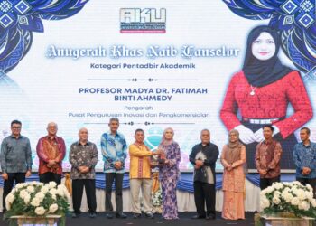 KASIM Mansor menyampaikan anugerah kepada salah seorang penerima.