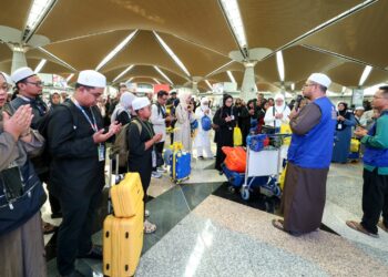 PARA jemaah mengaminkan bacaan doa sebelum berangkat ke Tanah Suci pada pelepasan kumpulan umrah Andalusia Pakej Mesra Hari 9H7M penerbangan Malaysia Airlines di KLIA Terminal 1, Sepang, - UTUSAN/FAISOL MUSTAFA