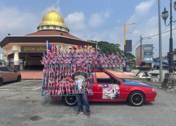 ARBAAIN Mohamad menunjukkan kereta Proton Iswara Aeroback yang dihiasi sebanyak 369 bendera Jalur Gemilang.