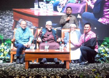 Muhamad Muqharabbin Mokhtarrudin memegang tongkat yang diserahkan Abdul Hadi Awang selepas memenangi bidaan bernilai RM16,500 pada Majlis Makan Malam Amal Pas Melaka di sebuah hotel di Ayer Keroh malam tadi. UTUSAN/AMRAN MULUP