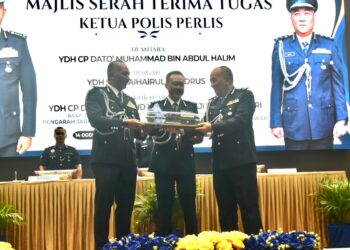 MUHAMMAD Abdul Halim (kiri) menyerahkan tongkat kuasa kepada Zaihairul Idrus (kanan) sebagai simbolik penyerahan tugas Ketua Polis negeri di IPK Perlis, semalam. -UTUSAN/ASYRAF MUHAMMAD