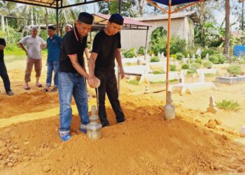 AHLI keluarga menyiram pusara Harun Awang Ngah di Tanah Perkuburan Islam Felda Kerteh 5, Dungun, Terengganu.