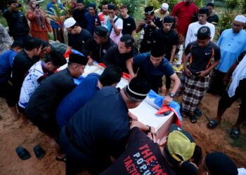 AHLI keluarga dan rakan membantu semasa pengebumian jenazah Allahyarham Koperal Nur Hafiz Rahim yang maut  akibat terkena renjatan elektrik ketika bertugas di Tanah Perkuburan Islam Kampung Pangkal Kuang, Ketereh, Kota Bharu, Kelantan. - UTUSAN/KAMARUL BISMI KAMARUZAMAN