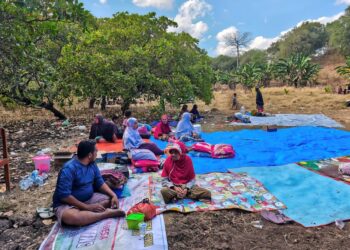 PENDUDUK berlindung di kawasan lapang di Sikka. - AFP