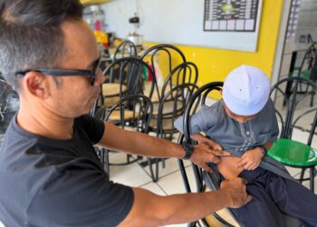 SHAMSUL Azrin Man menunjukkan bahagian badan anaknya yang lebam didakwa akibat dipukul pelajar senior di sebuah maahad tahfiz di Alor Setar.