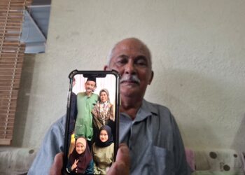 MOHD. Nadzri menunjukkan gambar keluarga adik iparnya, Shaik Mohd. Firdaus yang terkorban bersama dua anak perempuannya dalam nahas jalan raya di Jalan Sultan Ismail di Kuala Lumpur awal pagi tadi.