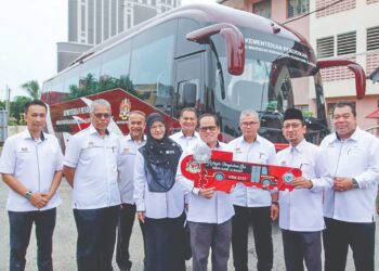 MOHD. Azam Ahmad (empat, kanan) menyerahkan replika kunci bas kepada pengetua  SMKA Naim Lilbanat Raisham Ab. Rashid di Kota Bharu, Kelantan, semalam. – UTUSAN/KAMARUL BISMI KAMARUZAMAN