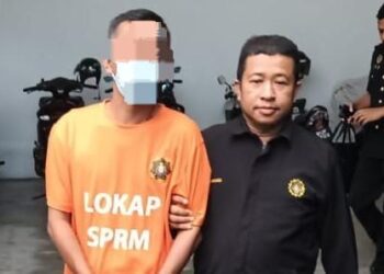 SUSPEK semasa dibawa oleh anggota SPRM untuk mendapatkan perintah reman bersabit kes rasuah di Mahkamah Kota Bharu, Kelantan. - IHSAN SPRM