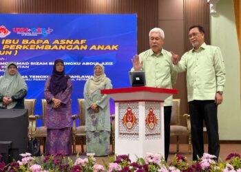 MOHAMAD Rizam Tengku Abdul Aziz (kiri) melakukan gimik perasmian aplikasi e-Comel di Kompleks Islam Jubli Perak Sultan Ismail Petra, Kota Bharu, Kelantan, hari ini.-UTUSAN/ ROSLIZA MOHAMED.