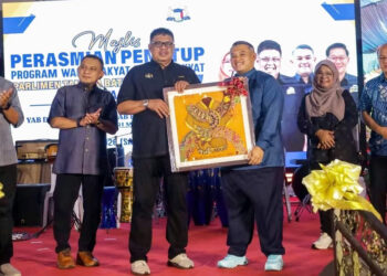 Rauf Yusoh menerima cenderamata daripada Rais Yasin selepas Majlis Perasmian Penutupan WRUR Parlimen Tangga Batu: Kampung Kita DUN Paya Rumput di Stadium Hang Jebat, Krubong, malam tadi.