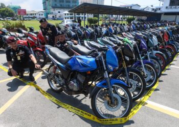 MOHD. Khairi Khairudin (kiri) menunjukkan motosikal Yamaha RXZ yang disita atas pelbagai kesalahan semasa Program RXZ Members 8.0 di Ibu pejabat Kontinjen (IPK) Terengganu, Kuala Terengganu. -UTUSAN/PUQTRA HAIRRY