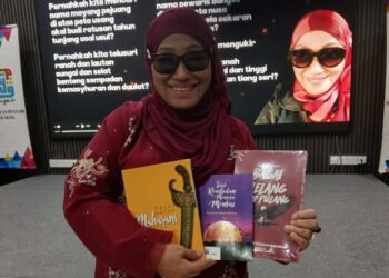 Barupawati Utamaju menunjukkan beberapa buku yang memuatkan hasil penulisan puisinya.