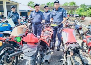 MOHD. Hisham Mohd Nor (kanan) memeriksa motosikal seludup dari Thailand di Pejabat JKDM Rantau Panjang Kelantan, Kelantan. - UTUSAN/ROHANA ISMAIL