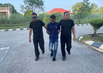 MOHAMMAD Asrul Aisyal Abdullah Manap dibawa anggota polis untuk prosiding perbicaraan di Mahkamah Kota Bharu, Kelantan. - UTUSAN/ROSMIZAN RESDI