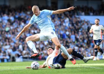 Penyerang Manchester City, Erling Haaland diasak pertahanan Coventry City, Ethan Pinnock, ketika aksi Liga Perdana Inggeris di Stadium Etihad.-AFP