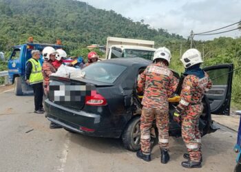 PIHAK bomba mengeluarkan mangsa yang tersepit dalam nahas di Kampung Gambaron, Telupid, Sabah pagi tadi.-IHSAN JBPM SABAH