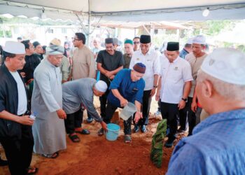 KAMARUDIN Salleh (empat, kiri) menyiramkan air ke pusara Dr. Ainul Baraah di Tanah Perkuburan Islam Sri Kedeper, Baung, Pengkalan Chepa, Kota Bharu, Kelantan, semalam.
