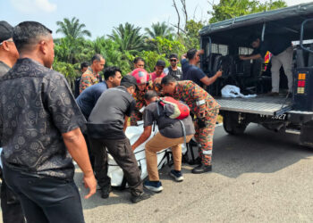 ANGGOTA bomba dan polis mengangkat tong berisi rangka manusia untuk dibawa ke Hospital Melaka dalam kejadian yang berlaku di kawasan Empangan Durian Tunggal. - UTUSAN