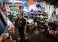 PEMILIK kedai runcit berdiri di dalam premisnya yang ditenggelami air di daerah Bang Kapi, Bangkok.- AFP