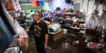 PEMILIK kedai runcit berdiri di dalam premisnya yang ditenggelami air di daerah Bang Kapi, Bangkok.- AFP