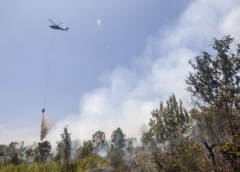 SEBUAH helikopter digunakan untuk memadamkan terbakar di kawasan Tegal Arum dan Guntung Damar, Banjarbaru, Kalimantan Selatan. - AFP
