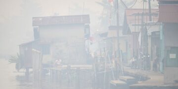 SEORANG lelaki duduk di tepi Sungai Kapuas ketika asap tebal dan jerebu menyelubungi bandar Pontianak di Kalimantan Barat.- AFP