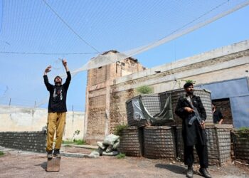 ANGGOTA pasukan keselamatan memasang jaring penghadang bagi mengelak serangan dron di balai polis di wilayah Khyber Pakhtunkhwa, Pakistan.-AFP 