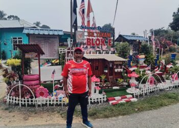 ROSLI Hashim berdiri di hadapan replika rumah peneroka dan hiasan taman di Felda Sungai Tekam, Jerantut, Pahang. – UTUSAN/HARIS FADILAH AHMAD