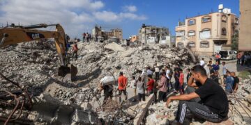 PENDUDUK Palestin melihat anggota Pertahanan Awam menggali runtuhan Menara Al-Muhandisin di tengah Gaza yang musnah akibat serangan Israel menyasarkan Hamas. - AFP