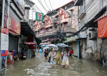 PENDUDUK meredah banjir di daerah Bang Bua selepas hujan lebat selama hampir 48 jam menyebabkan paras air meningkat di semua daerah di ibu negara Thailand semalam.- AFP