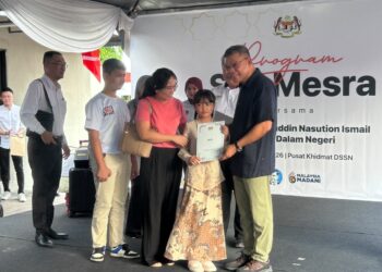 SAIFUDDIN Nasution Ismail menyampaikan dokumen kewarganegaraan kepada seorang kanak-kanak pada Program Sua Mesra di Taman Sejahtera, Lunas di Kulim.
