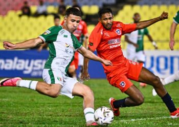 PEMAIN Kuching City FC, Ramadan Saifullah melakukan percubaan sambil dihalang pemain Melaka FC, V. Ruventhiran dalam aksi Liga Super di Stadium Hang Jebat, kelmarin.- IHSAN KUCHING CITY FC