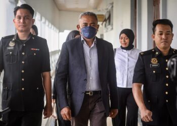 ADI Azuan Abdul Ghani diiringi pegawai Suruhanjaya Pencegahan Rasuah Malaysia (SPRM) ketika hadir bagi pertuduhan terima kos ubah suai rumah bernilai lebih RM8,000 di Mahkamah Sesyen, di sini hari ini.