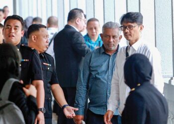 Tengku Kamarolhisham Kamaruddin (kanan) dan Nasahruddin Ahmad (baju hijau) hadir di Mahkamah Sesyen Kuala Lumpur semalam bagi menghadapi dakwaan berkaitan RCI Tabung Haji.