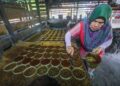 ESAH Adam menuang manisan yang masih panas ke dalam kerek (daun mengkuang yang dilingkar menjadi bentuk bulat) untuk disejukkan semasa proses menghasilkan nisan kerek asli di Kampung Batangan, Marang, Terengganu. – MINGGUAN/PUQTRA HAIRRY