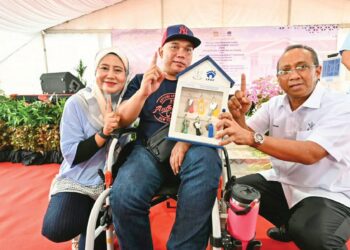 MOHAMMAD Fakhruddin Mohd. Ariff (kanan) menyerahkan kunci rumah Residensi Rakyat Pahang (RRP) kepada Mohd. Azuan Mohd Amin dan  Hanisah Abd. Kadir di Taman Seri Inderapura di Kuantan, Pahang. – UTUSAN/SHAIKH AHMAD RAZIF