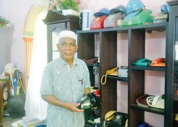 ABDUL Majid Hussin menunjukkan model telefon era 70-an berdekatan rak koleksi 37 buah telefon lama di Kampung Kuala Keloi di Raub, Pahang. – UTUSAN/HARIS FADILAH AHMAD