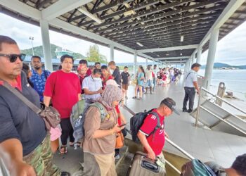 SUASANA di Jeti Pangkor yang dipenuhi pelancong untuk menaiki feri ke Lumut selepas bercuti di Pulau Pangkor ketika tinjauan semalam. - UTUSAN/AIN SAFRE BIDIN