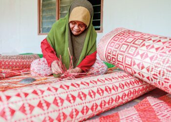 CHE Teh Ambak melakukan proses menganyam tikar daun pandan laut yang diusahakannya di Kampung Gong Batu, Setiu, Terengganu. – MINGGUAN/PUQTRA HAIRRY