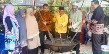 AHMAD Fahmi Ahmad Sarkawi (kanan) mengacau bubur asyura pada pada program ramah mesra bersama pelajar Sekolah Agama Islam Sirithamwittaya (Pondok Duku), Kampung Duku, Daerah Bacho, Narathiwat, Thailand. – UTUSAN/ RAZALI ZAKARIA