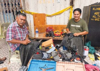 SAZALI Latif (kiri) bersama Mohd. Nazri menjahit kasut di kaki lima di Jalan Temenggong, Kota Bharu, Kelantan. – UTUSAN/ROSLIZA MOHAMED