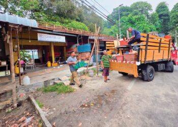 PENIAGA memindahkan barang dan peralatan perniagaan di Teluk Nipah ke lokasi perniagaan baharu ketika tinjauan di Pangkor semalam. – UTUSAN/AIN SAFRE BIDIN