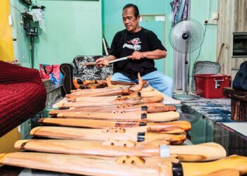 KHALIB Samah menunjukkan sebahagian sarung dan hulu parang yang dihasilkannya di Perumahan Rantau Perintis, Bandar Pusat Jengka di Maran, Pahang. – UTUSAN/HARIS FADILAH AHMAD