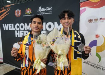 Farish Luzman (kanan) dan Muhammad Hariz Hazmi Hakimin menunjukkan pingat perak sebaik tiba di Lapangan Terbang Antarabangsa Kuala Lumpur (KLIA) dari Jepun, semalam. - IHSAN MSN