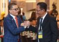 Shahril Mokhtar (kiri) bersalaman dengan Ab Ghani Hassan pada Kongres Luar Biasa Kedua FAM 2026 di Hotel Hilton, Petaling Jaya, semalam. - UTUSAN/ISKANDAR ISHAK