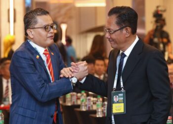 Shahril Mokhtar (kiri) bersalaman dengan Ab Ghani Hassan pada Kongres Luar Biasa Kedua FAM 2026 di Hotel Hilton, Petaling Jaya, semalam. - UTUSAN/ISKANDAR ISHAK