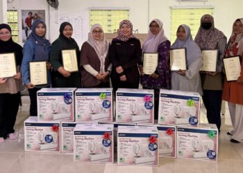 Dafinah Ahmed Hilmi,  (tengah), menyalurkan mesin jahit kepada usahawan graduan program SRI SURI di SURI Kilim Hub, Langkawi, Kedah.