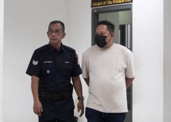 TERTUDUH semasa dibawa oleh polis untuk menghadiri prosiding perbicaraan di Mahkamah Sesyen Kota Bharu, Kelantan hari ini-UTUSAN/KAMARUL BISMI KAMARUZAMAN.